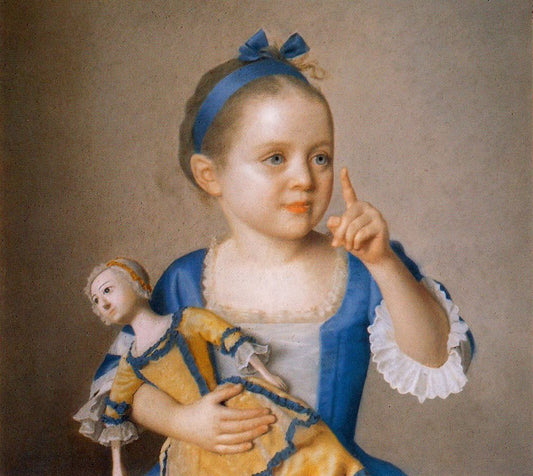 A young girl in a blue and white dress holding a wooden doll dressed in yellow and blue.
