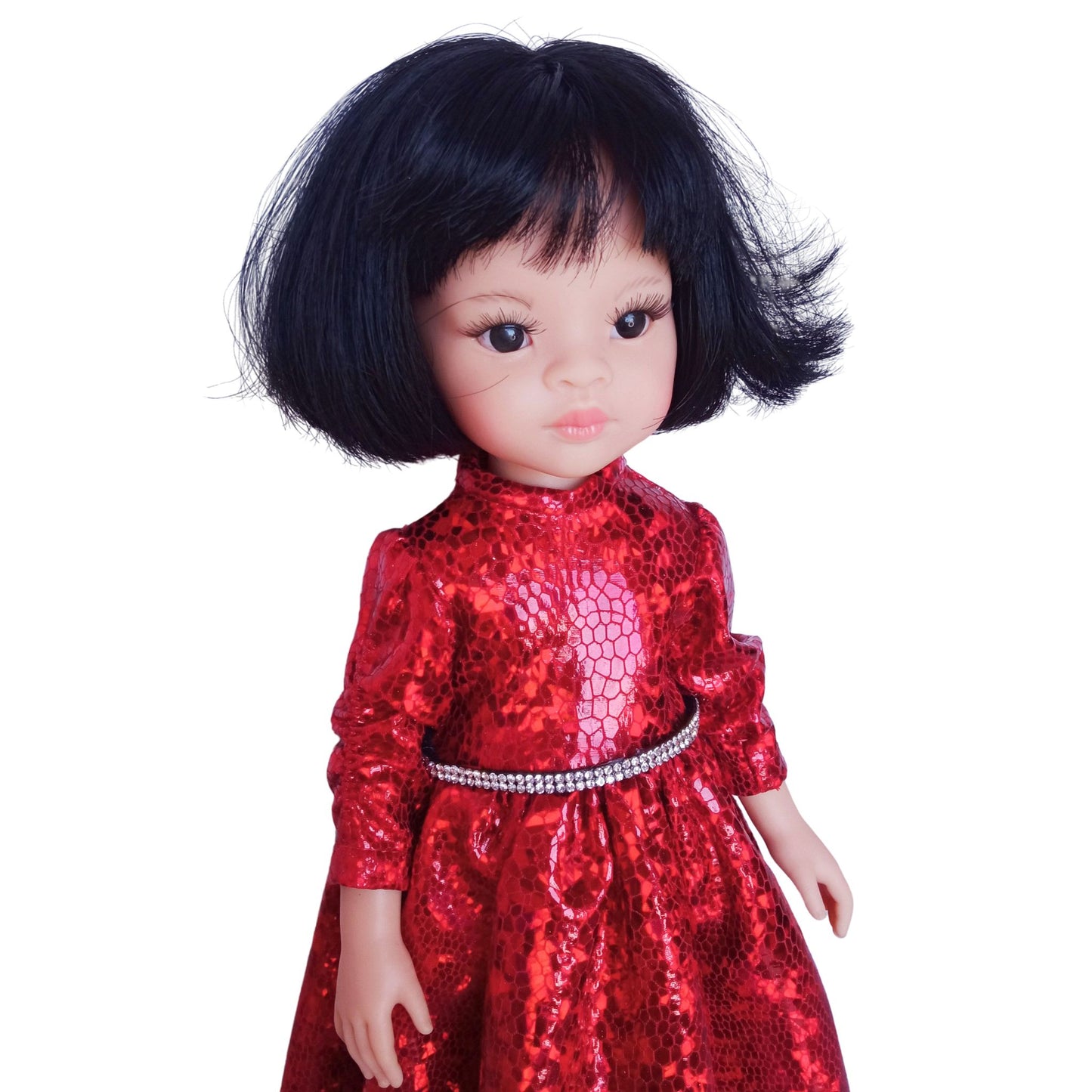 Paola Reina 32 cm doll wearing a red sparkling dress with a rhinestone belt and black patent leather shoes, standing against a white background.