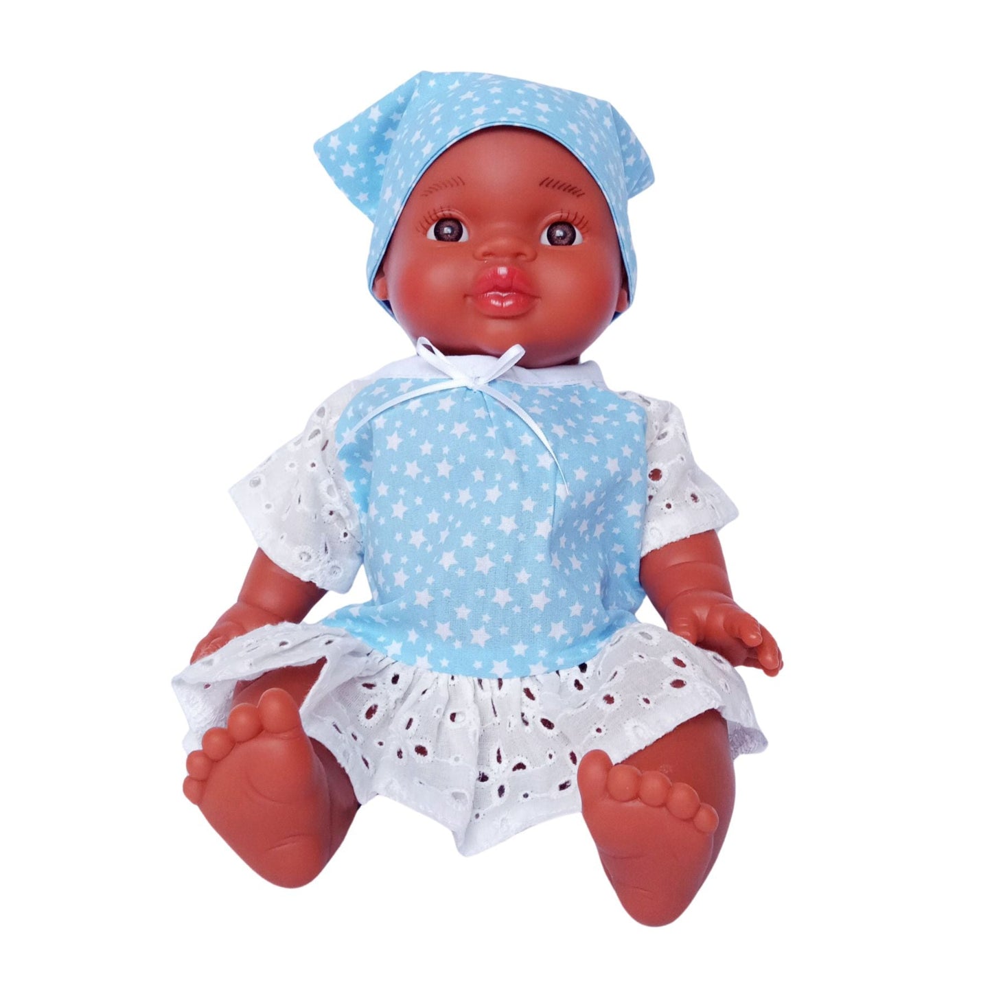 Dark-skinned baby doll wearing a blue star-print cotton dress with white eyelet lace and a matching kerchief, made for 34 cm dolls like Paola Reina and Baby Born.