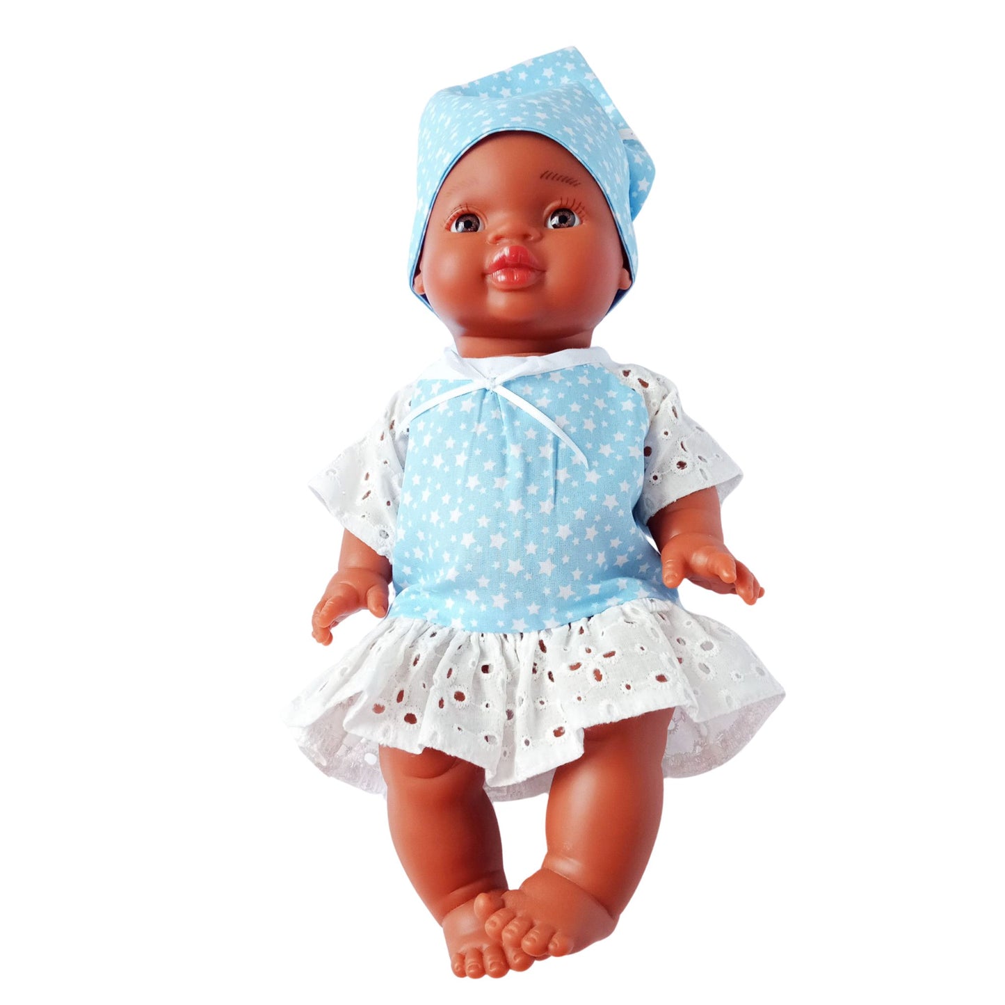 Dark-skinned baby doll wearing a blue star-print cotton dress with white eyelet lace and a matching kerchief, made for 34 cm dolls like Paola Reina and Baby Born.