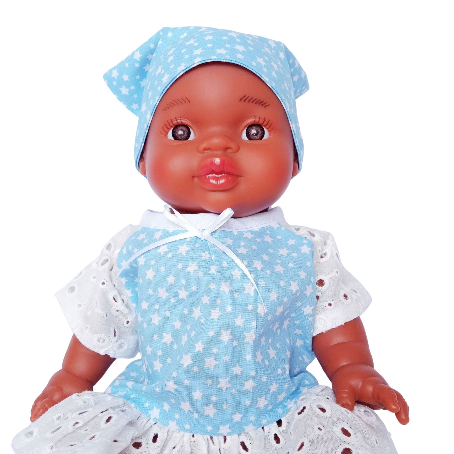 Dark-skinned baby doll wearing a blue star-print cotton dress with white eyelet lace and a matching kerchief, made for 34 cm dolls like Paola Reina and Baby Born.