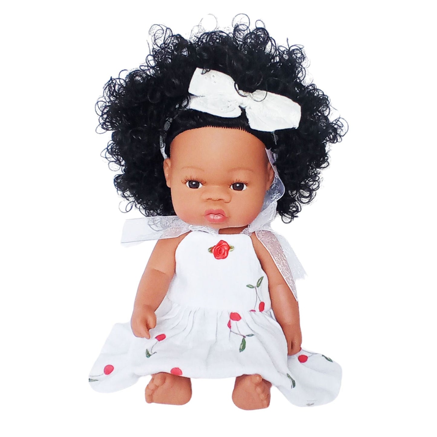 Dark-skinned curly-haired doll wearing a white summer cotton sundress with cherry print and red rose detail, designed for 34 cm dolls like Paola Reina or Baby Born.