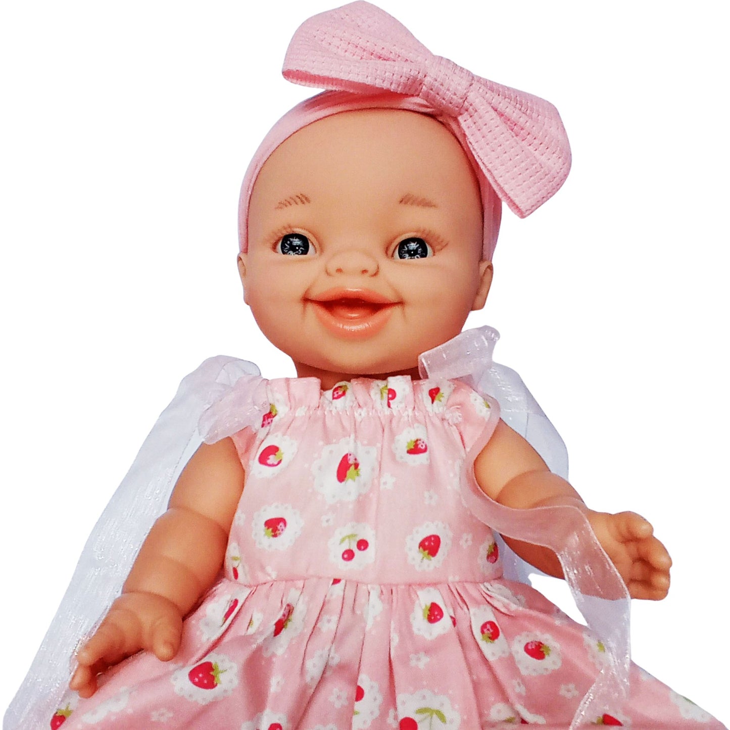 Smiling doll in pink strawberry print cotton sundress with white ribbon sleeves and pink bow headband, perfect for 34 cm Paola Reina or Baby Born dolls.
