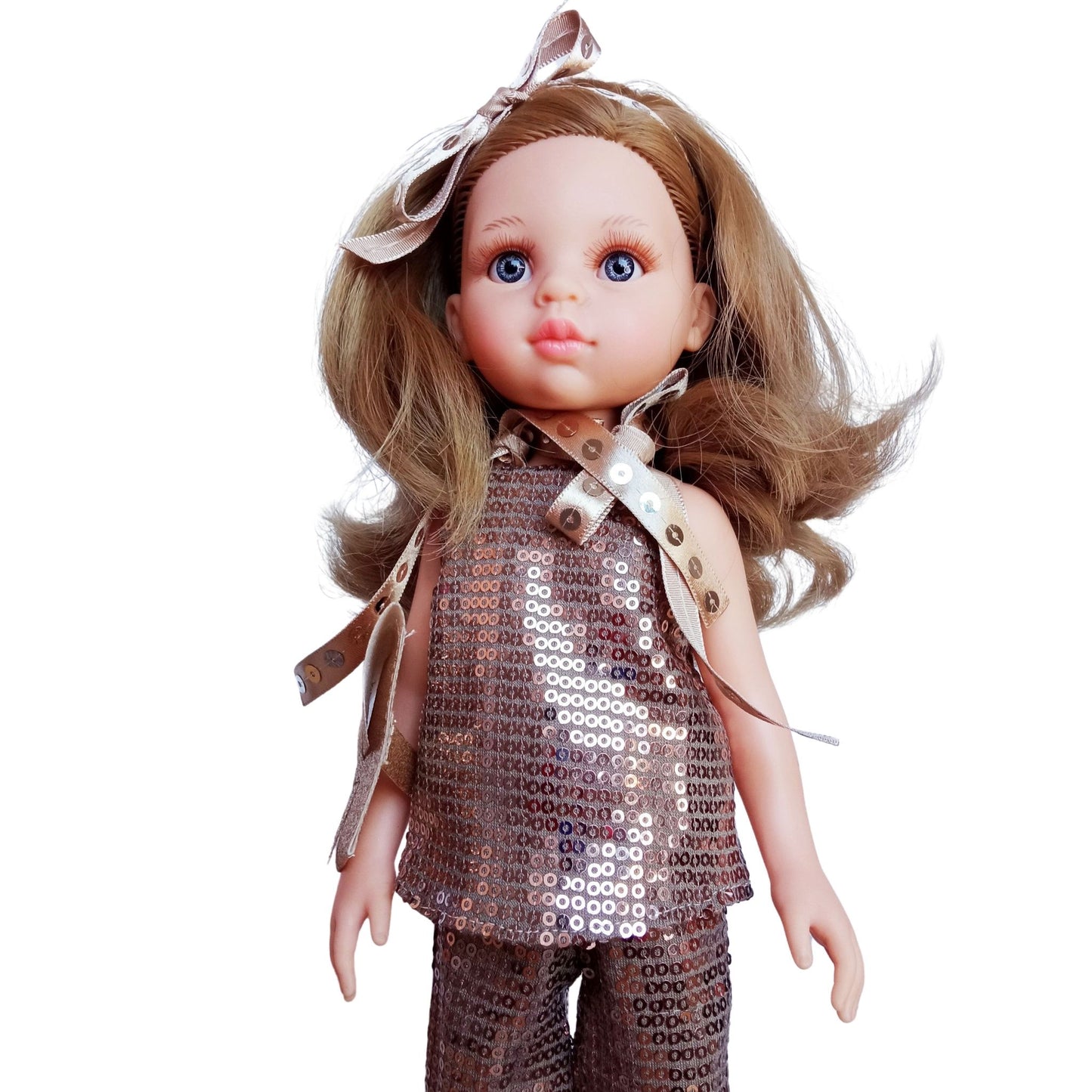 Paola Reina Carla 32 cm doll in a sparkling bronze sequin outfit with a clutch, ribbon accessories, standing against a white background.