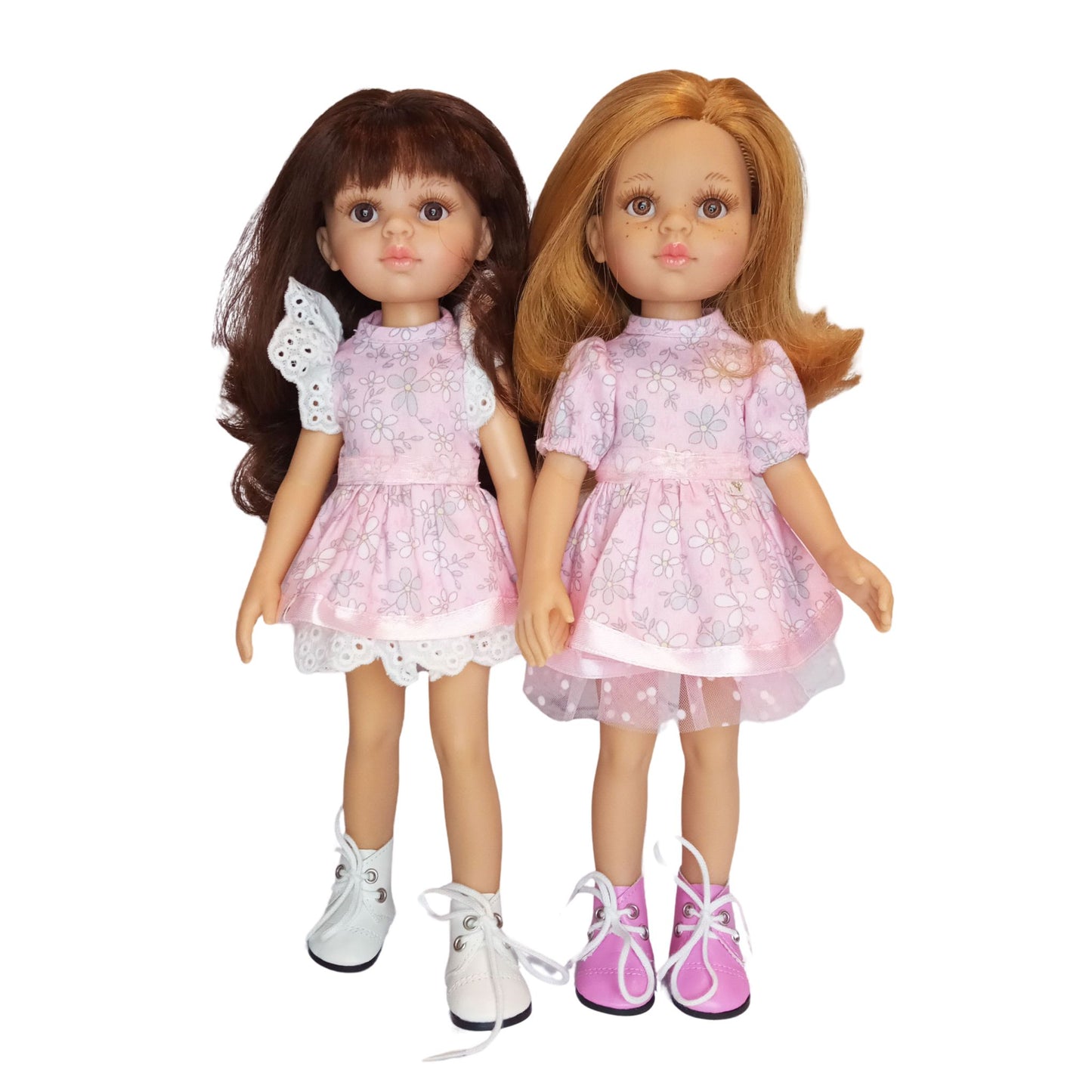 Two Paola Reina dolls wearing pink floral cotton dresses with lace and tulle details, styled with cute boots.