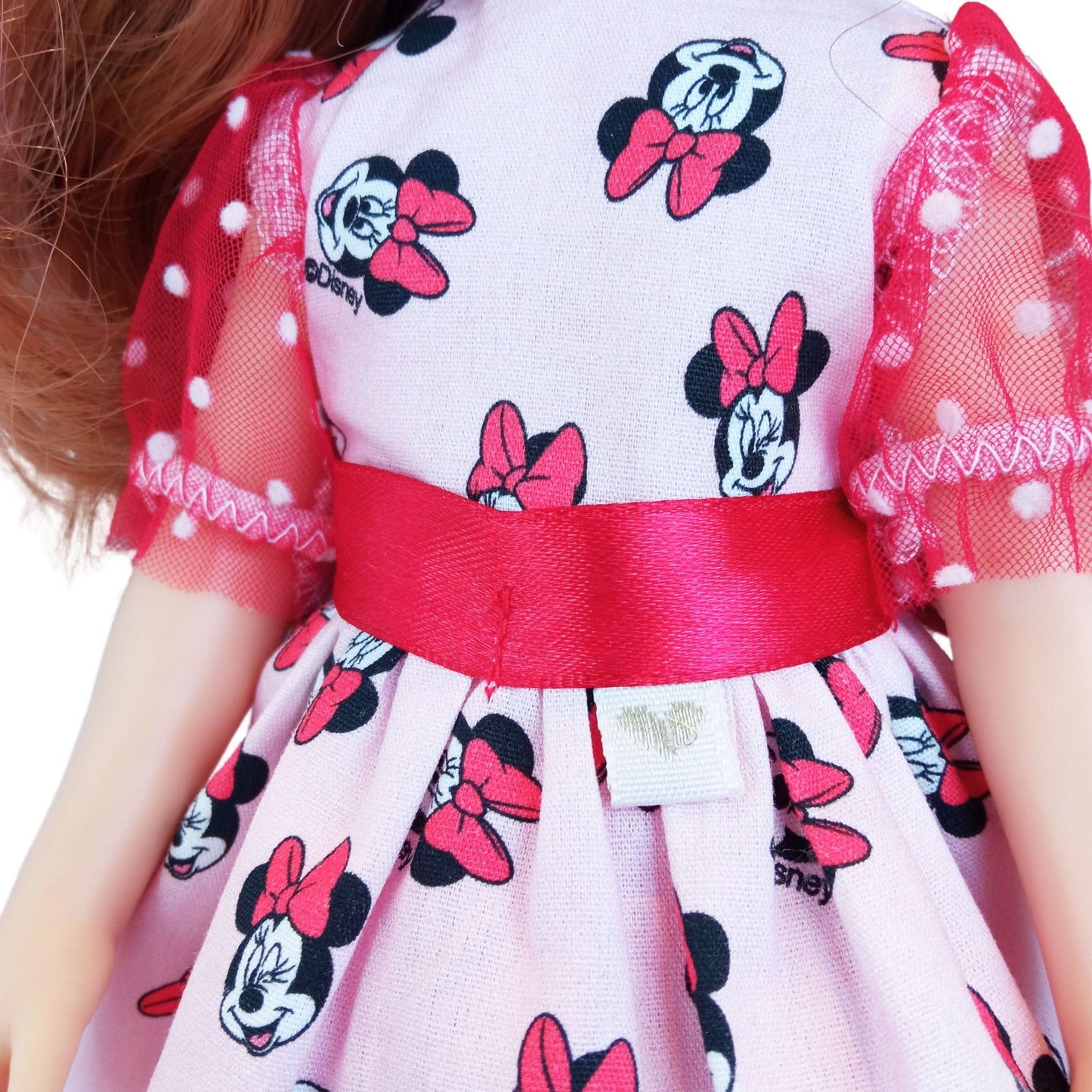 Paola Reina 32 cm doll wearing matching Minnie Mouse-inspired dresses with red satin bows and polka-dot mesh details.
