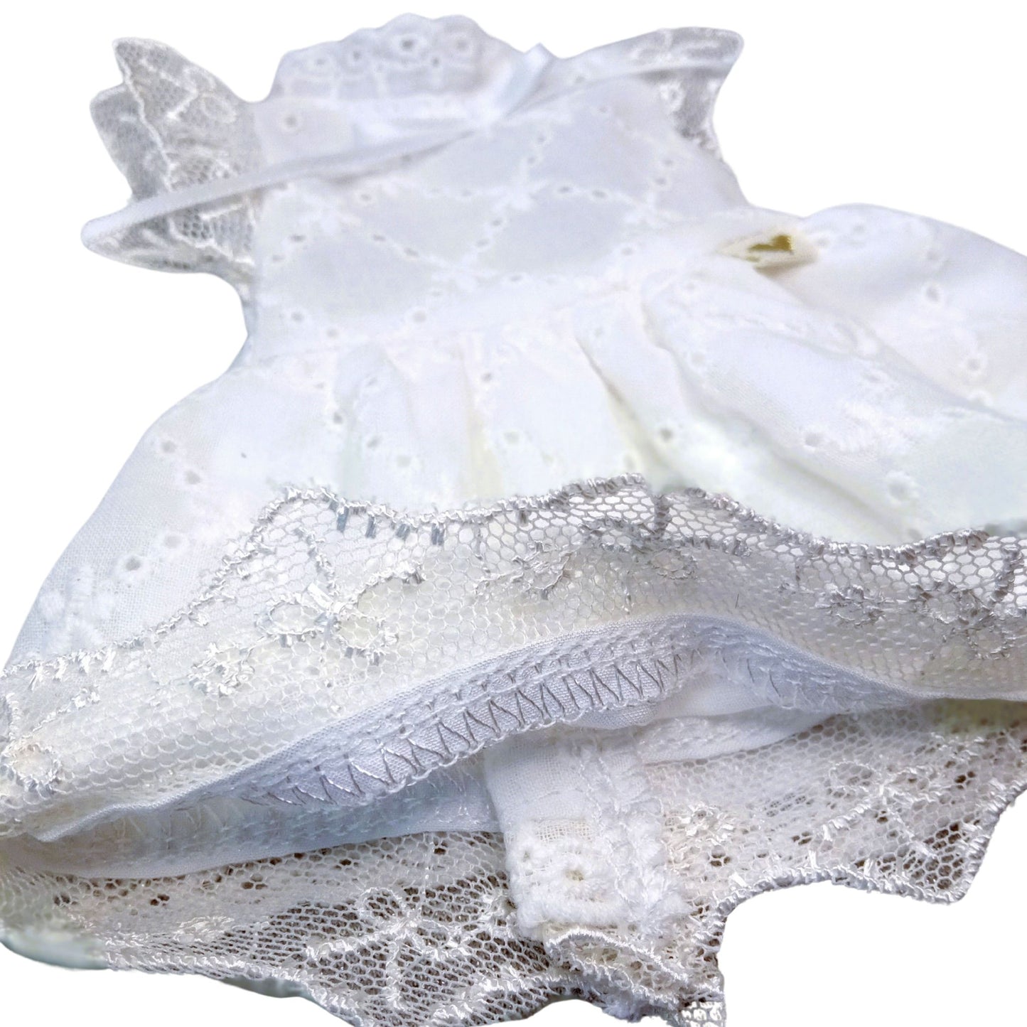 Handmade white lace dress for dolls with short black hair, featuring intricate lace details.