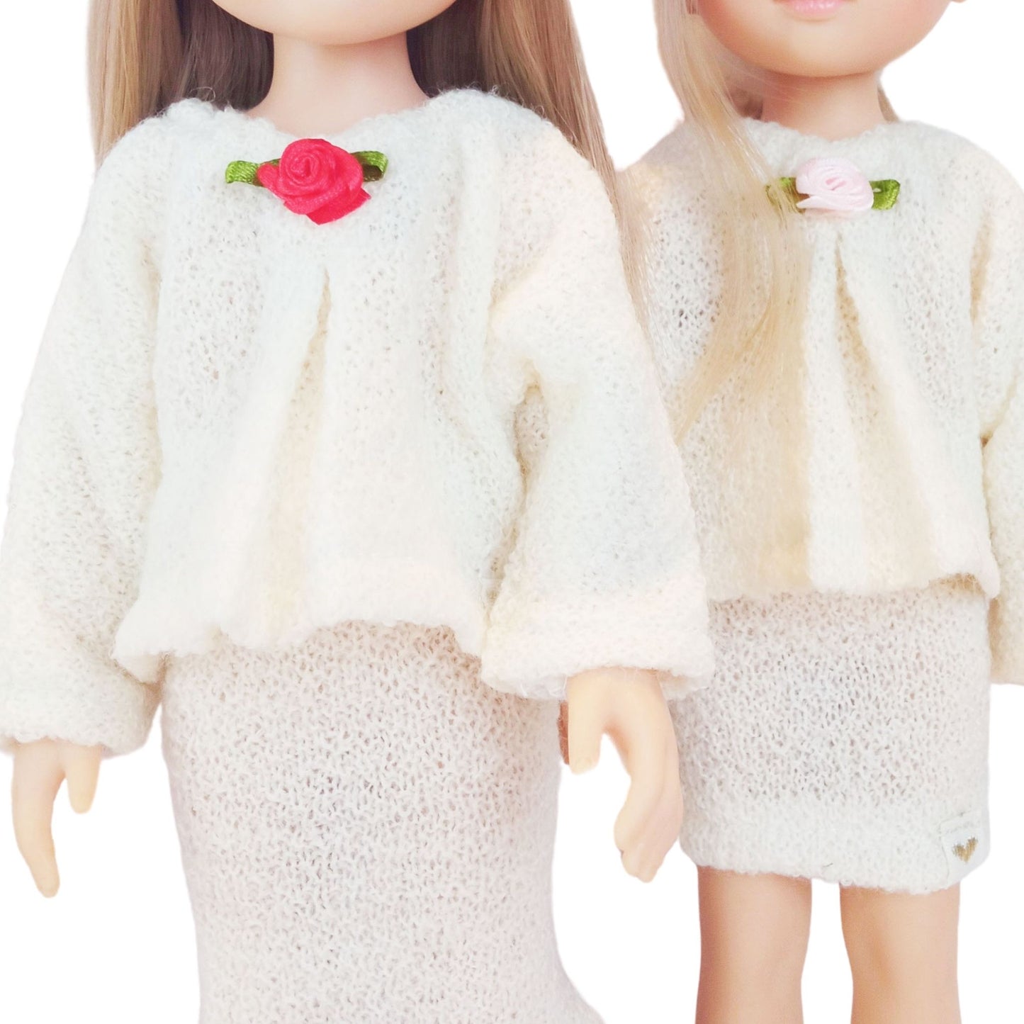 Two Paola Reina Las Amigas 32 cm dolls wearing handmade knitted jersey outfits with floral accents, featuring a top and matching skirt in two styles.