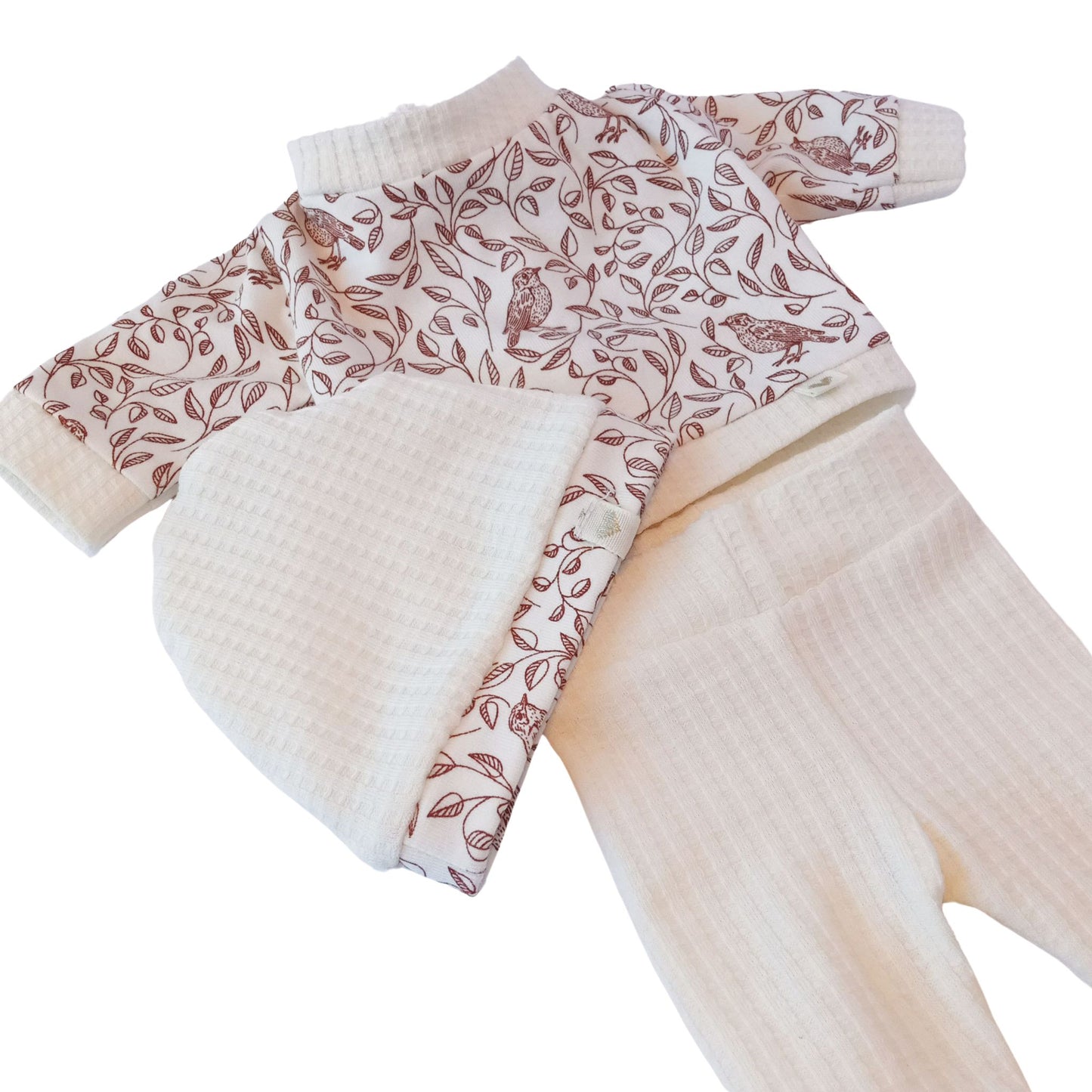 A 3-piece knit outfit including a white hat, printed blouse with leaves and birds, and white knit pants – perfect for Paola Reina or Baby Born 34 cm dolls.