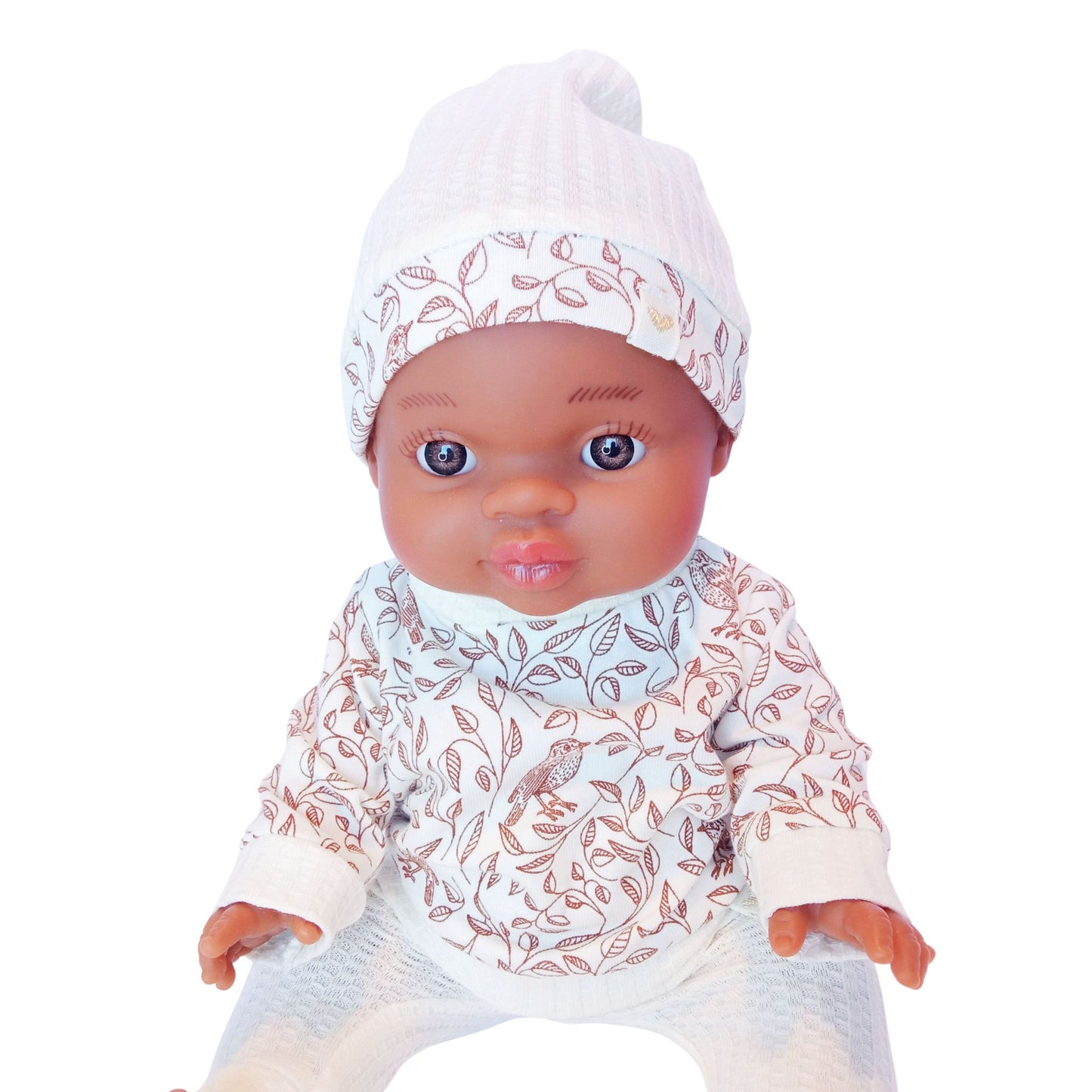 Dark-skinned doll in a 3-piece knit outfit including a white hat, printed blouse with leaves and birds, and white knit pants – perfect for Paola Reina or Baby Born 34 cm dolls.
