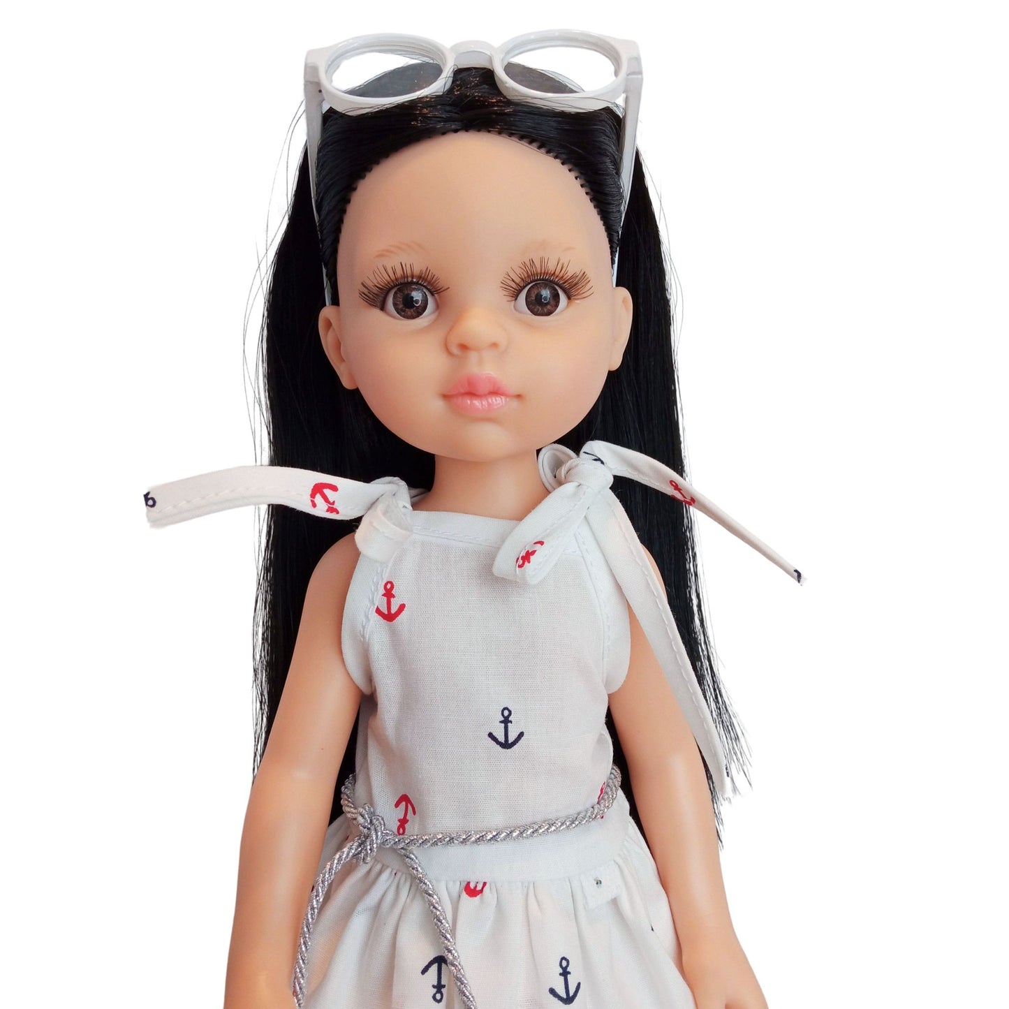 Paola Reina 32 cm doll wearing a white nautical dress with anchor prints, a silver belt, and stylish white sunglasses.