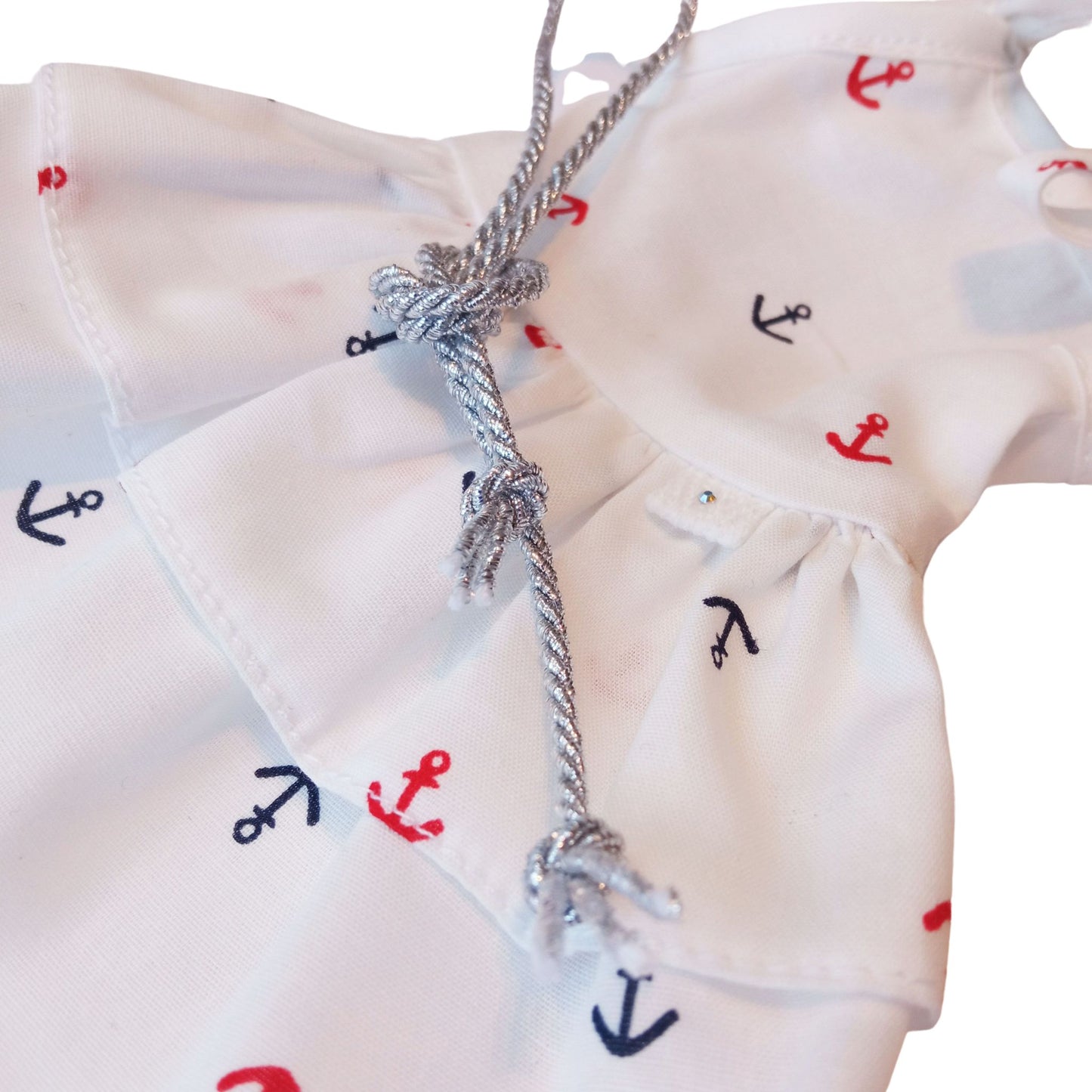 Paola Reina 32 cm doll wearing a white nautical dress with anchor prints, a silver belt, and stylish white sunglasses.