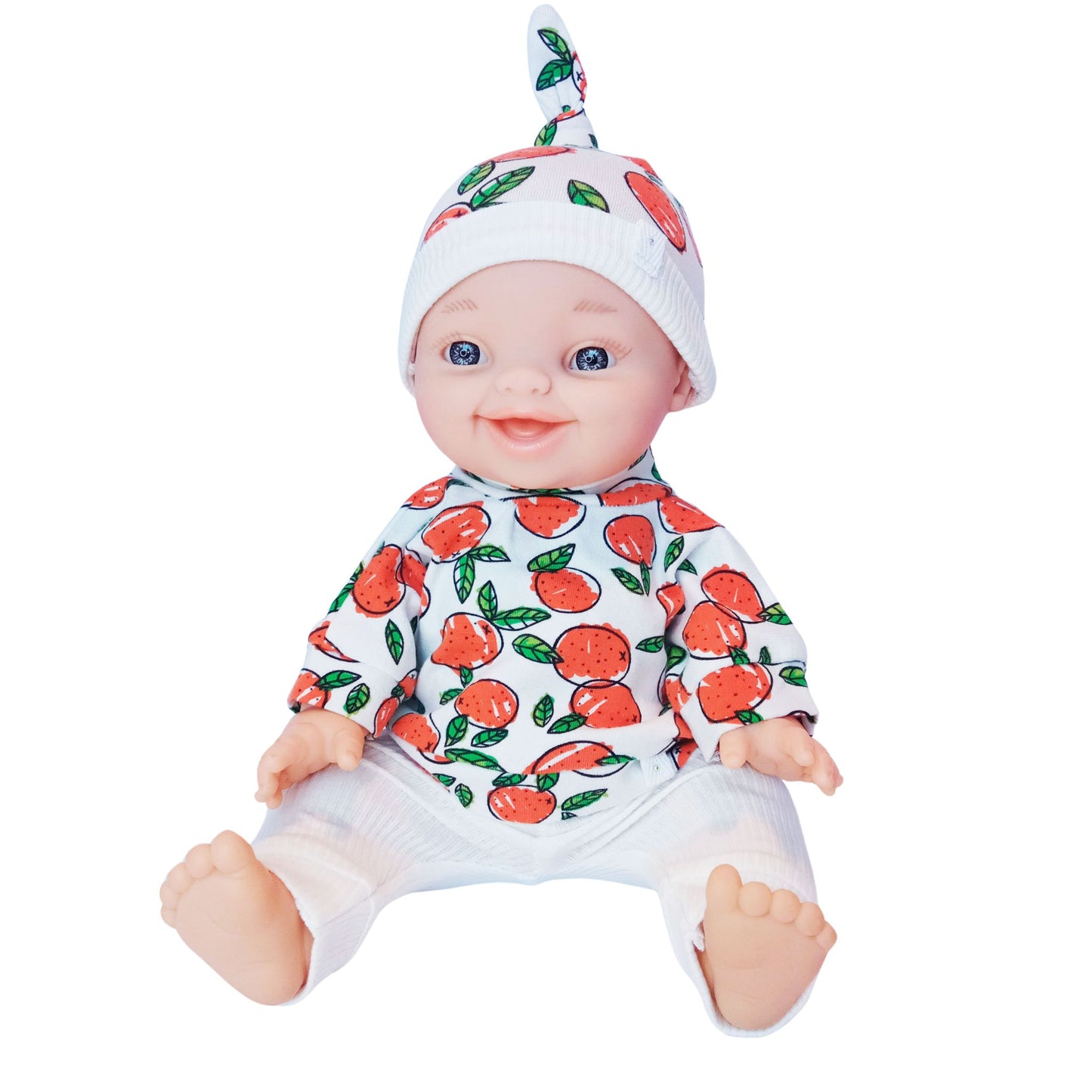 Smiling baby doll wearing a 3-piece knit outfit with orange fruit print blouse, white ribbed pants, and a matching citrus-themed hat – fits Paola Reina and Baby Born 34 cm dolls.