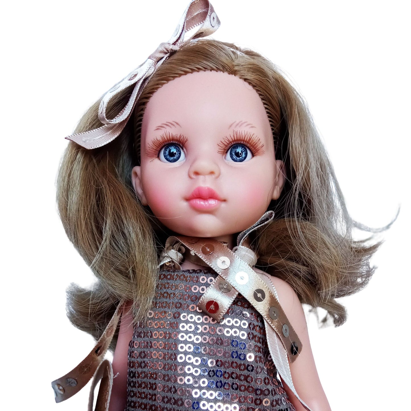 Paola Reina Carla 32 cm doll in a sparkling bronze sequin outfit with a clutch, ribbon accessories, and bronze patent leather shoes, standing against a white background.