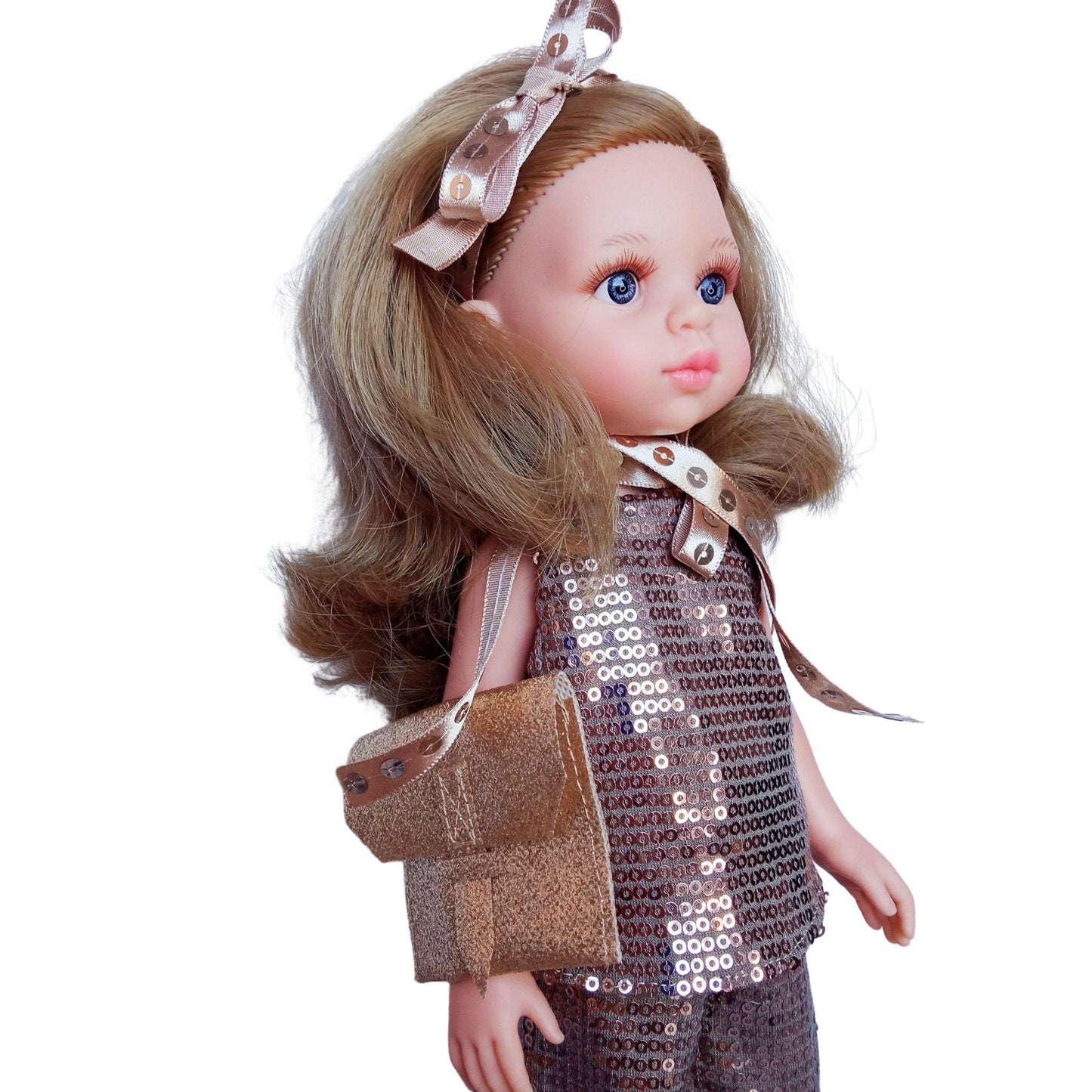 Paola Reina Carla 32 cm doll in a sparkling bronze sequin outfit with a clutch, ribbon accessories, and bronze patent leather shoes, standing against a white background.