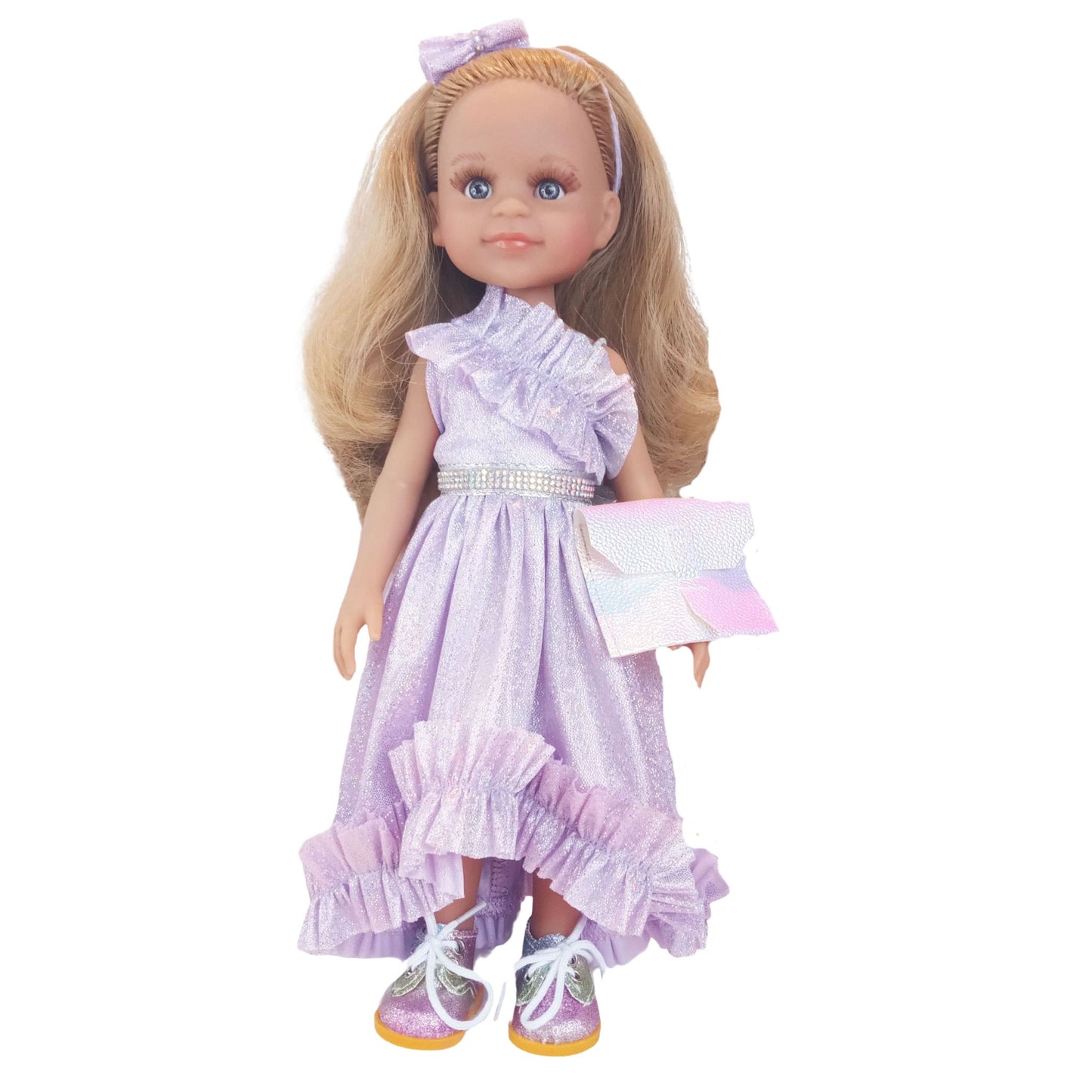 Paola Reina 32 cm doll wearing a lilac dress with ruffles, matching headband, holographic clutch, and glitter sneakers.