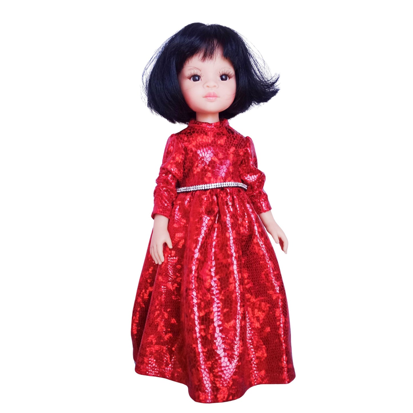 Paola Reina 32 cm doll wearing a red sparkling dress with a rhinestone belt and black patent leather shoes, standing against a white background.