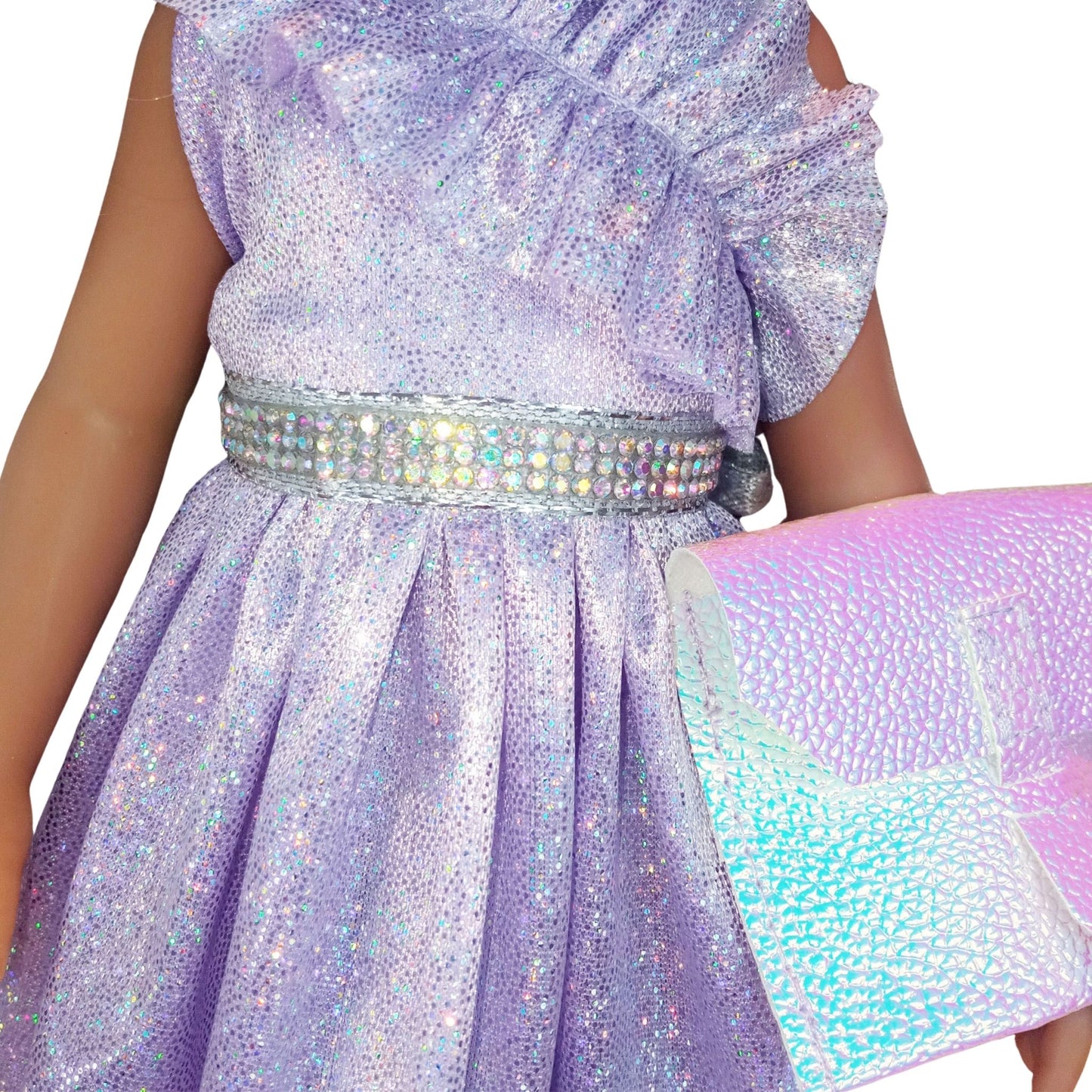 Paola Reina 32 cm doll wearing a lilac dress with ruffles, matching headband, holographic clutch.