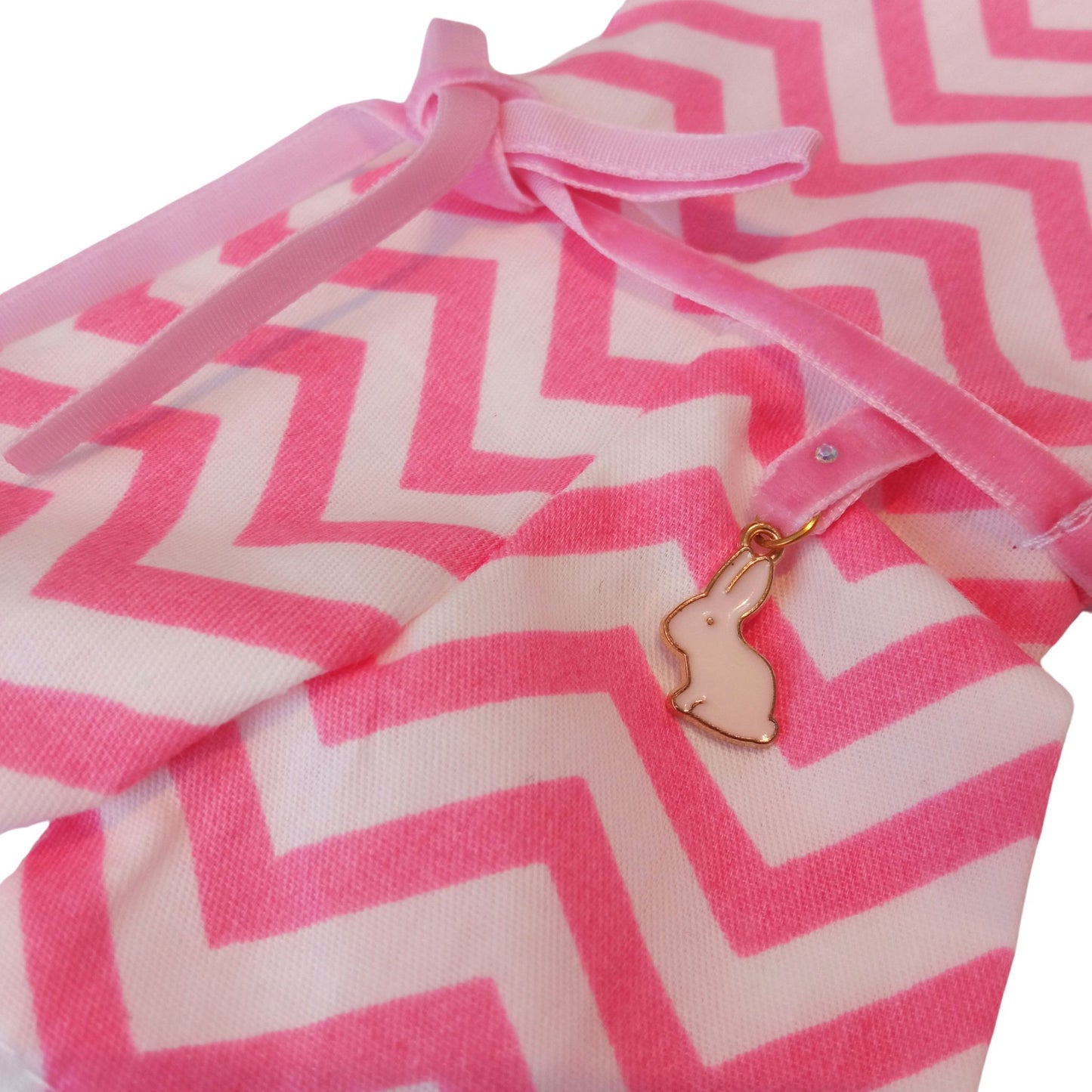Wearing a pink and white zigzag summer jumpsuit with a ribbon belt and matching headband for doll Paola Reina 32 cm doll.