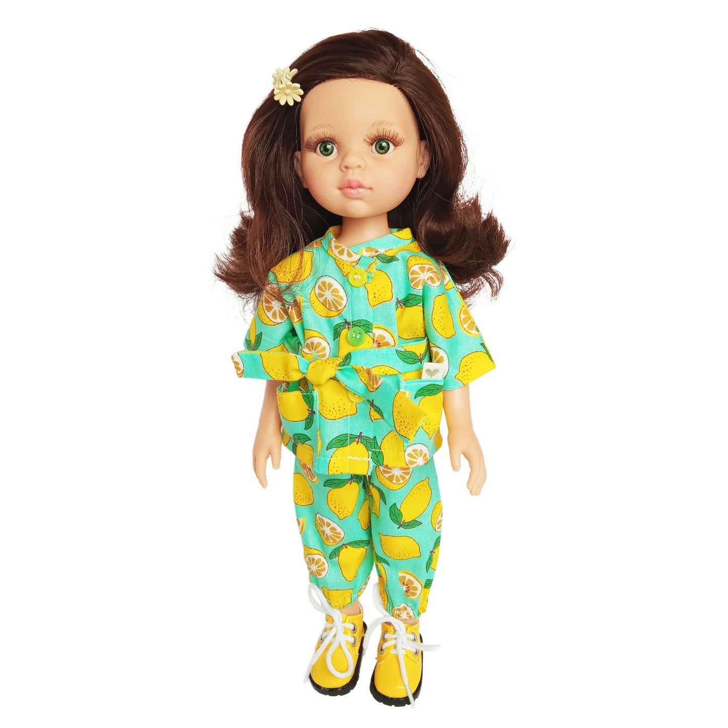 Paola Reina 32 cm doll wearing a bright lemon-printed jumpsuit with a matching belt, standing in yellow boots, styled for a cheerful summer look.