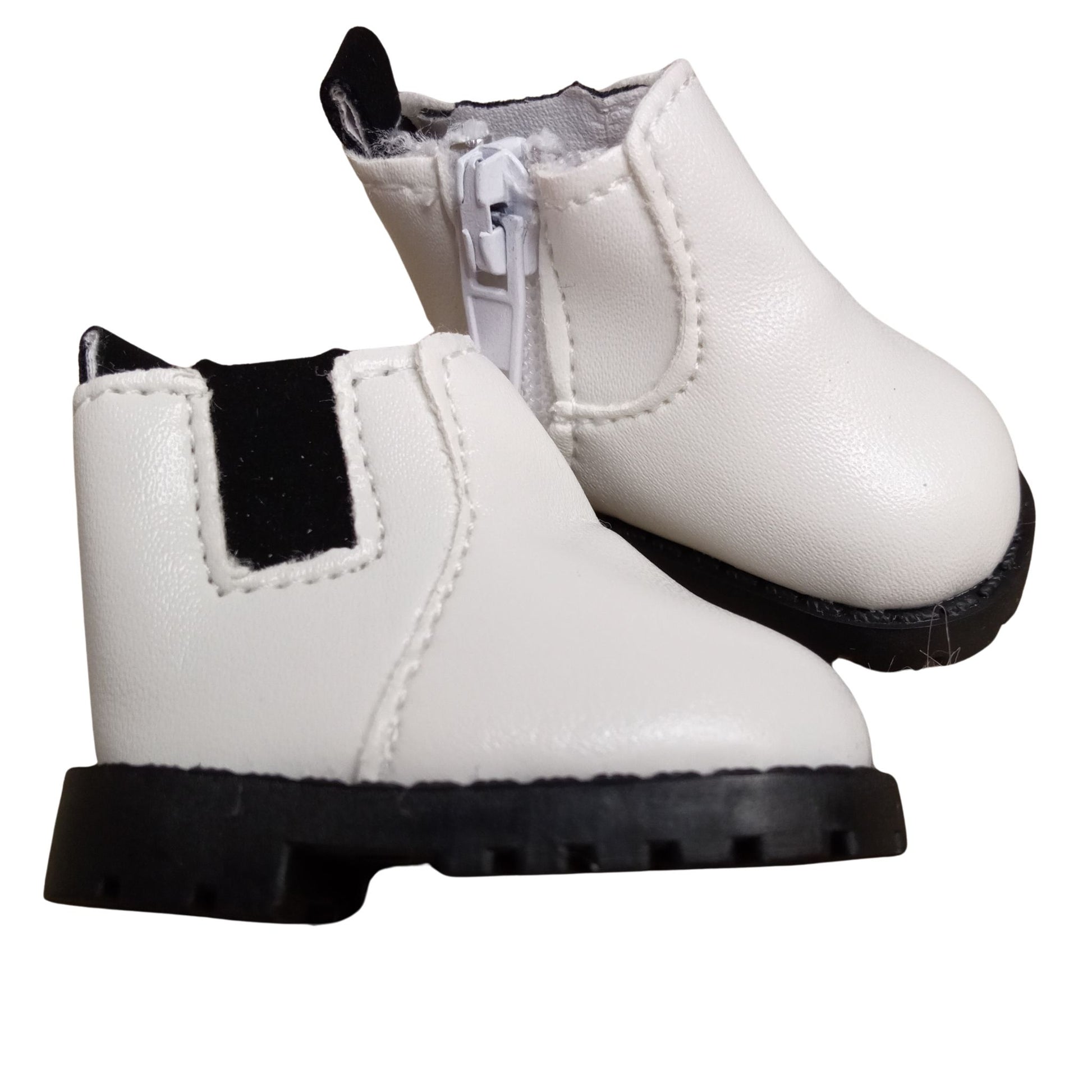 White Chelsea boots with black elastic accents and side zipper, designed for 32 cm Paola Reina dolls, featuring black rugged soles for a stylish and durable look.
